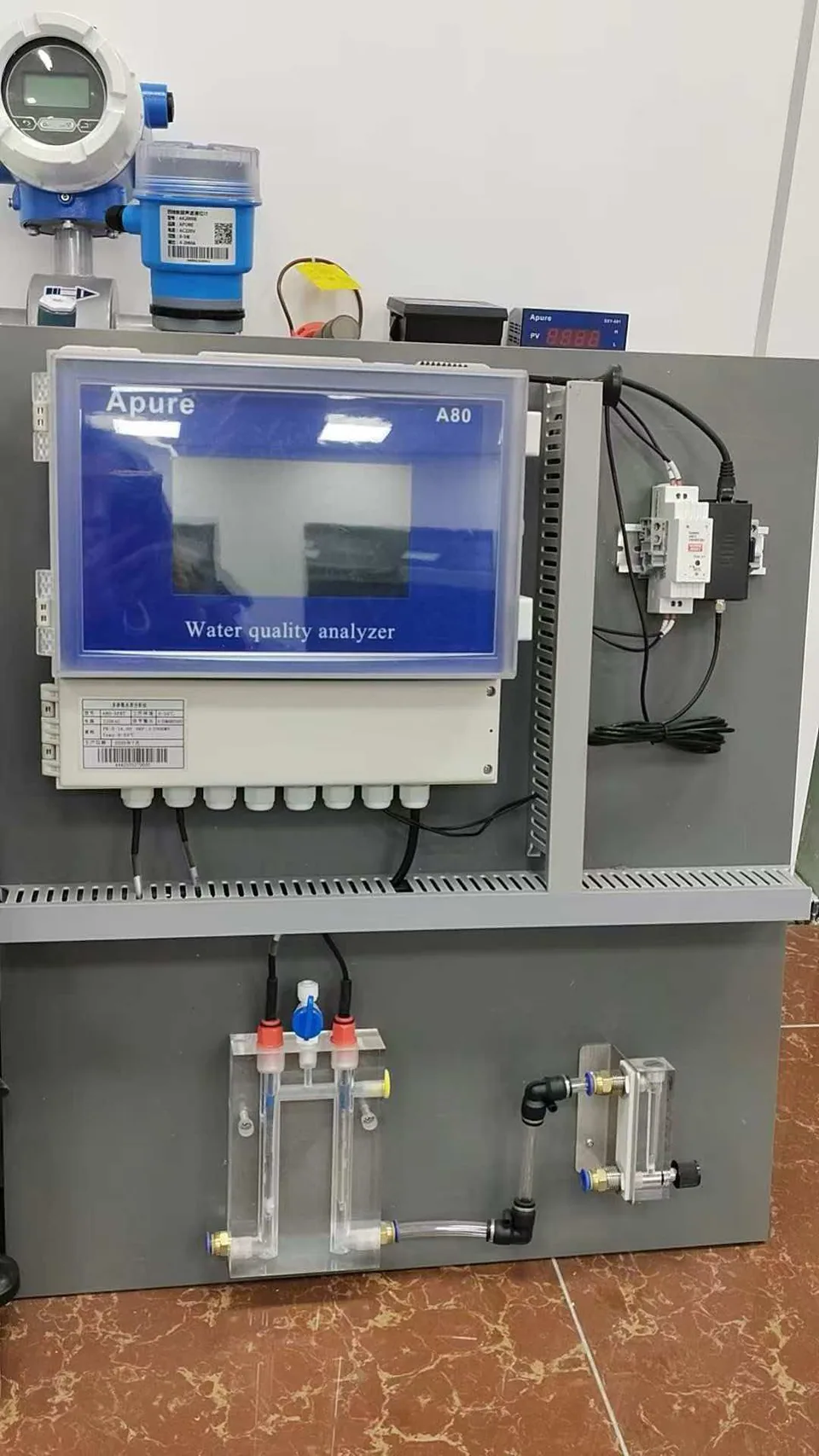 APURE A80 controller installed on a monitoring panel with sample-flow components